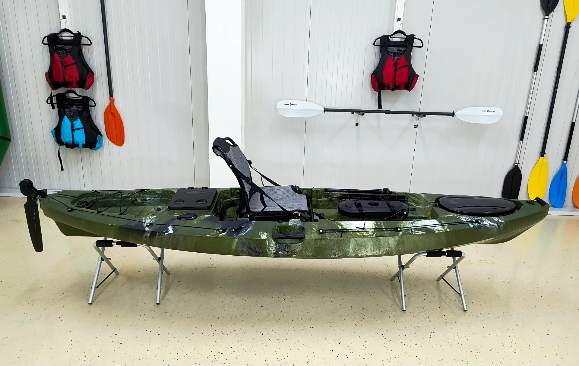 ONIX Hunter 320 zöld sit-on-top horgászkajak bemutatóteremben, magasított üléssel és fedélzeti tárolókkal.