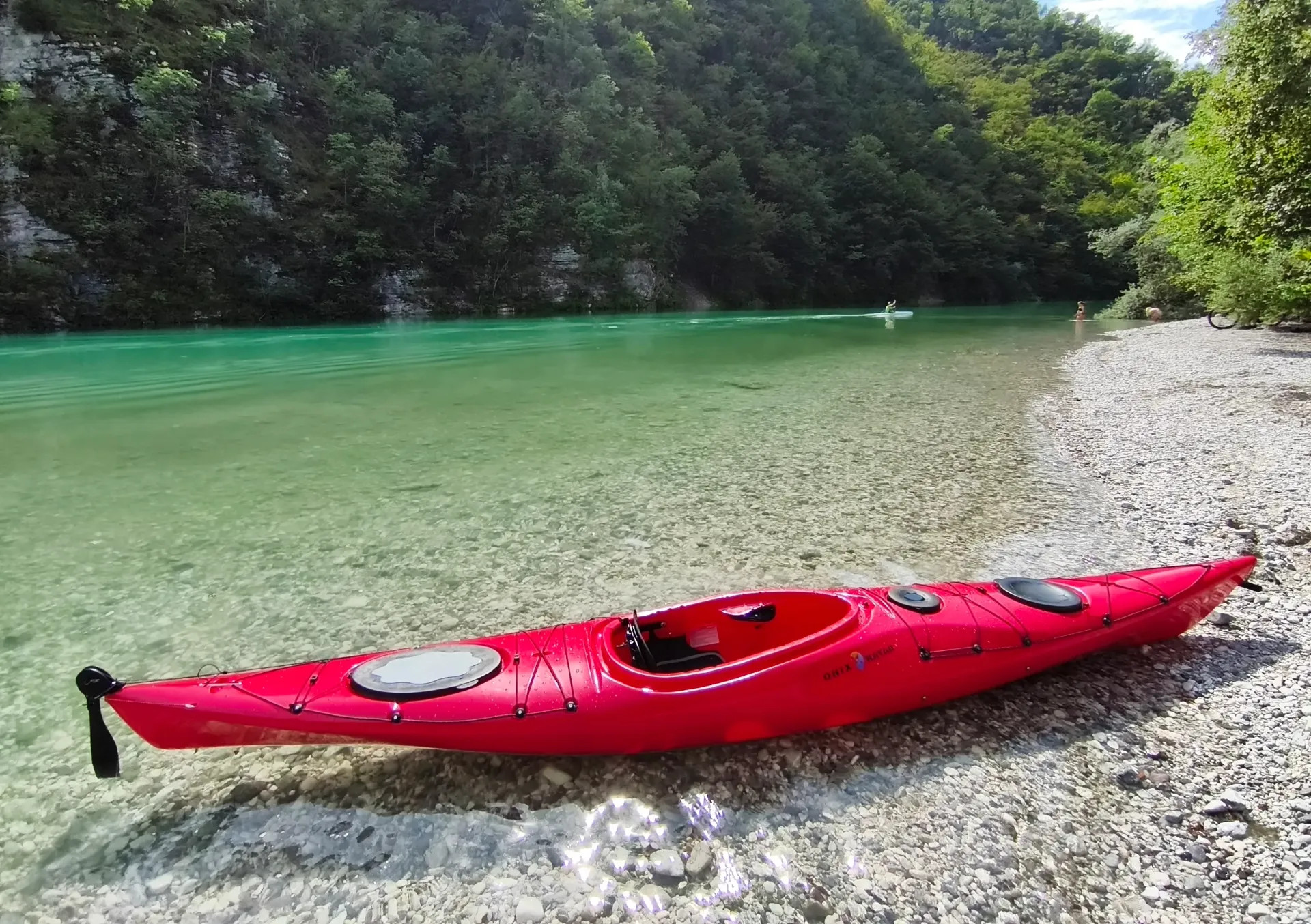 Piros ONIX Easytourer 430 túrakajak oldalnézetből, kavicsos folyóparton